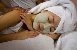 A woman enjoying a rejuvenating facial mask and massage at a spa for relaxation and skincare.